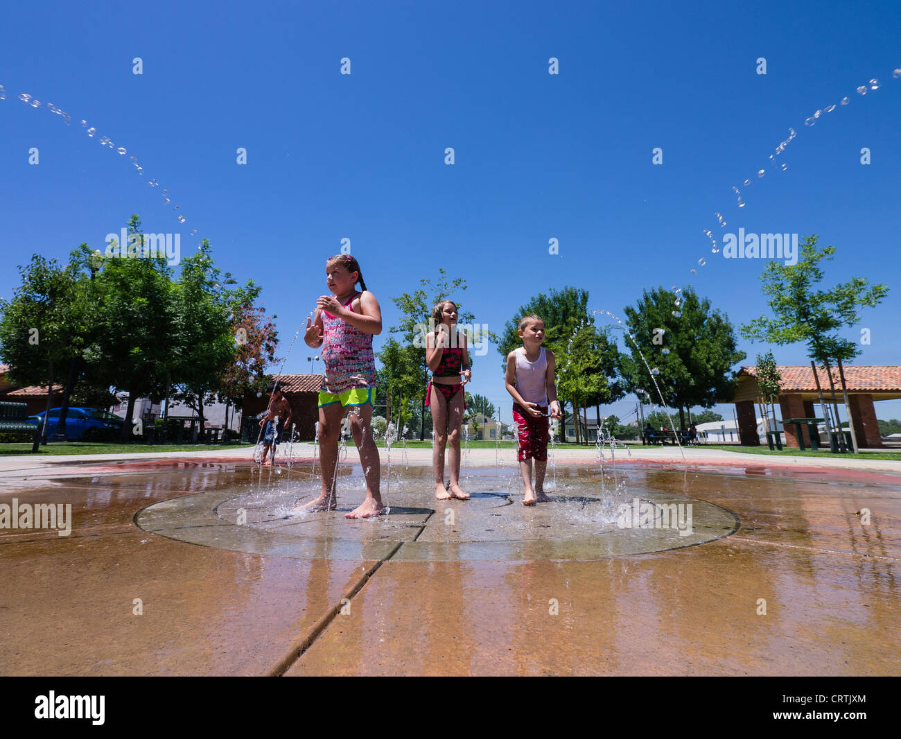 Kids play in a water feature in a local park in the Central Vally town