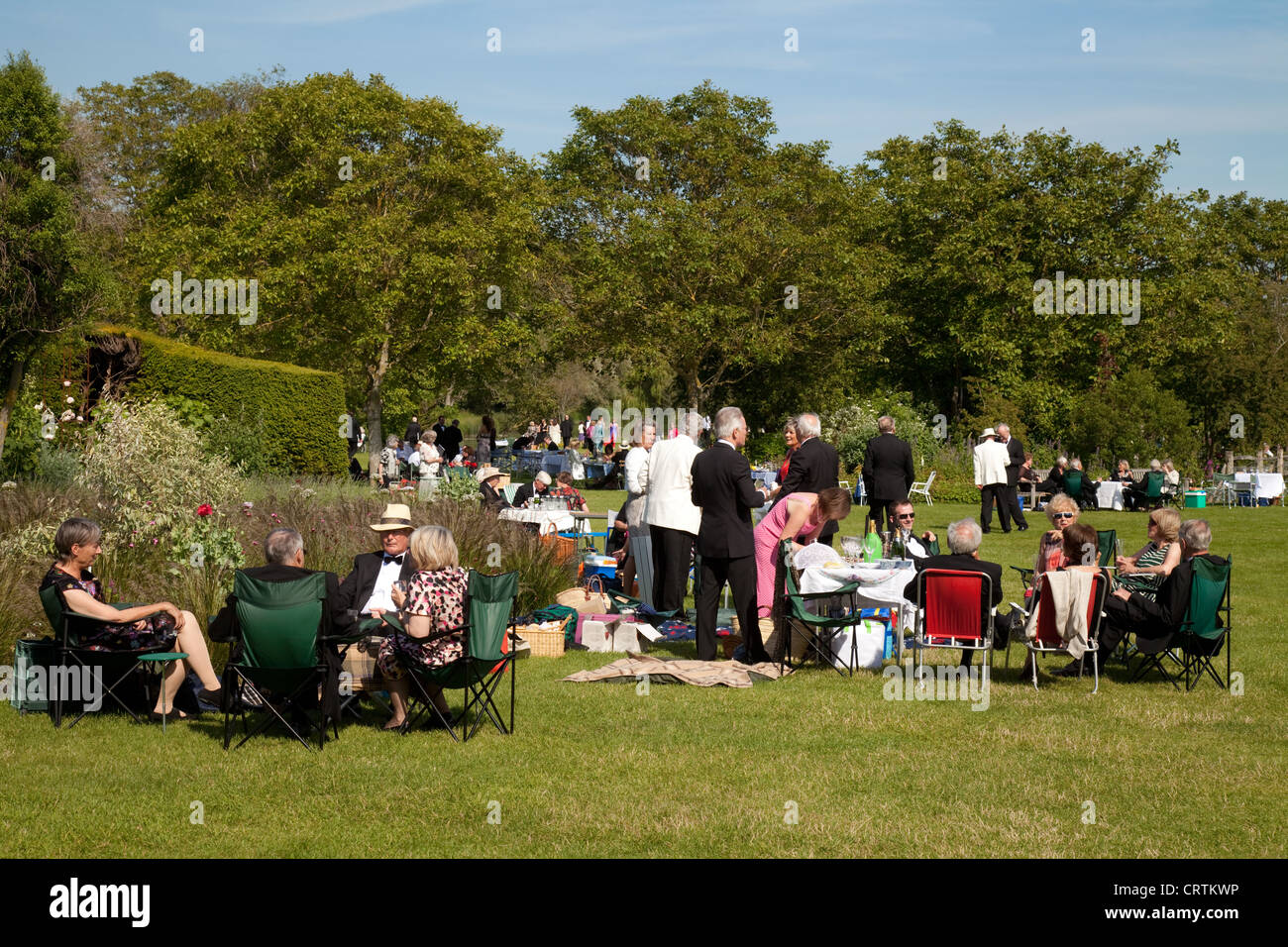 People having a picnic on the lawns at the Glyndebourne opera festival, Lewes, Sussex UK Stock Photo