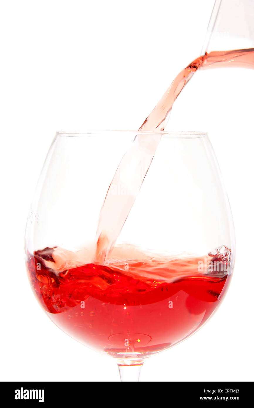 Pouring rose in glass over white background Stock Photo - Alamy