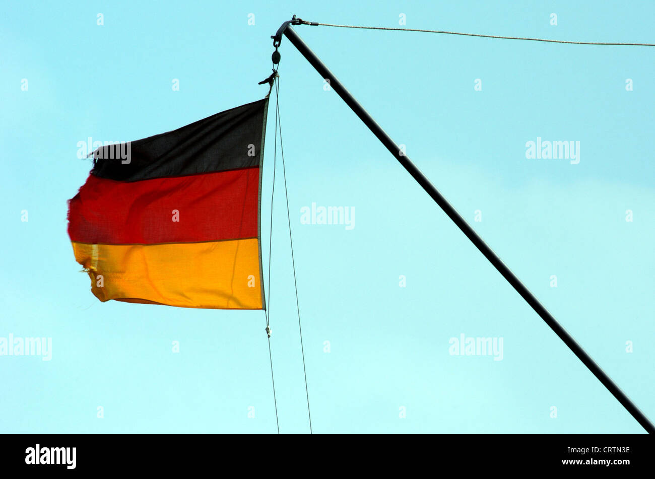 Waving, torn Germany flag in the wind Stock Photo