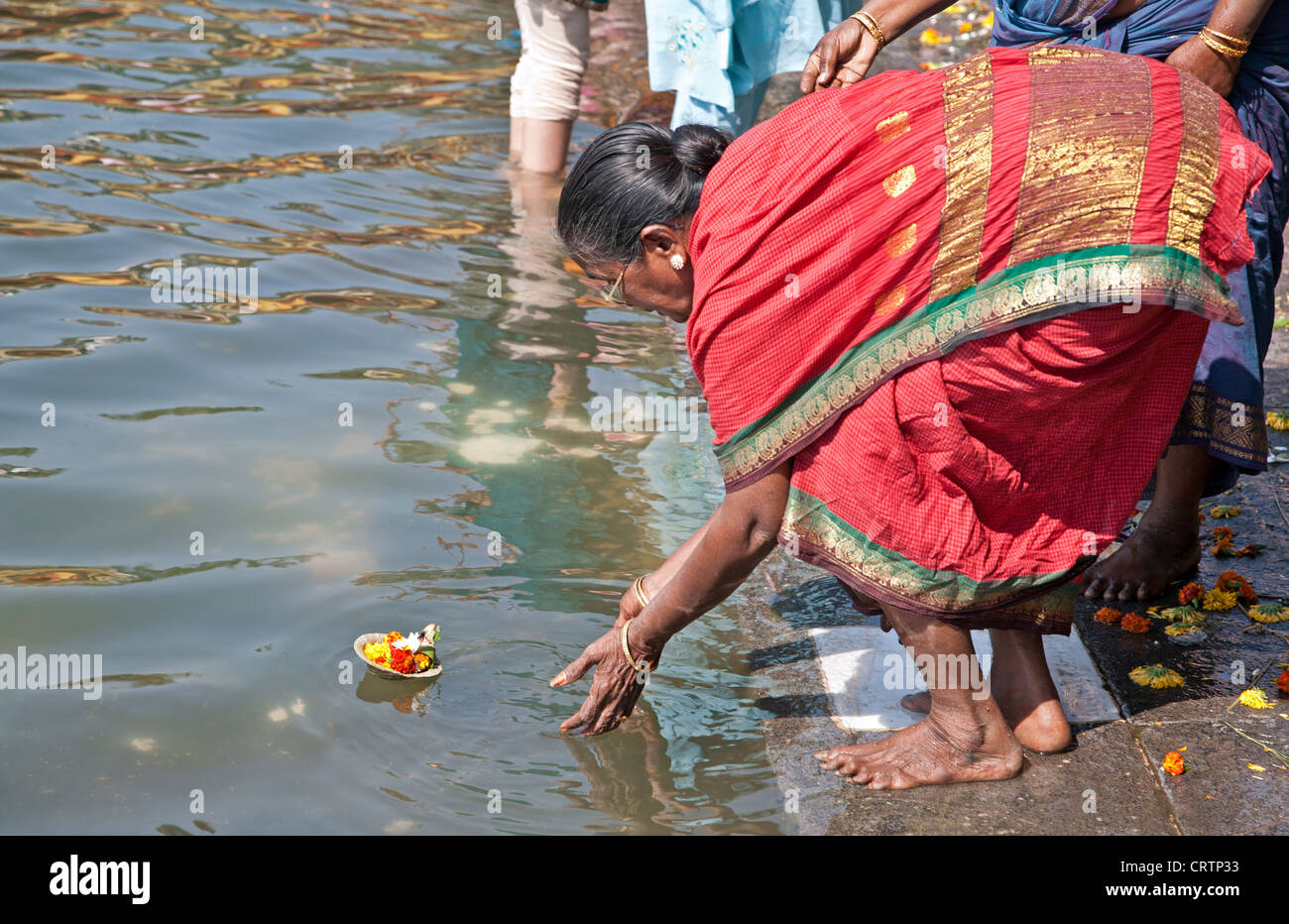 Woman making a river offering (puja). Ganges river. Varanasi (Benares). India Stock Photo