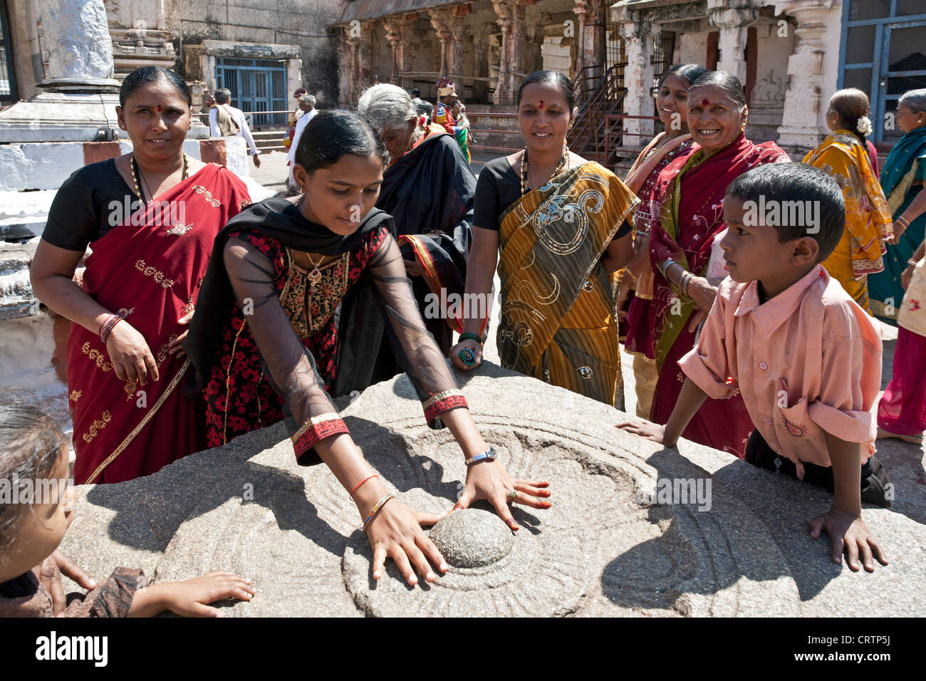 Women worshiping a sacred stone. Virupaksha temple. Hampi. India Stock Photo