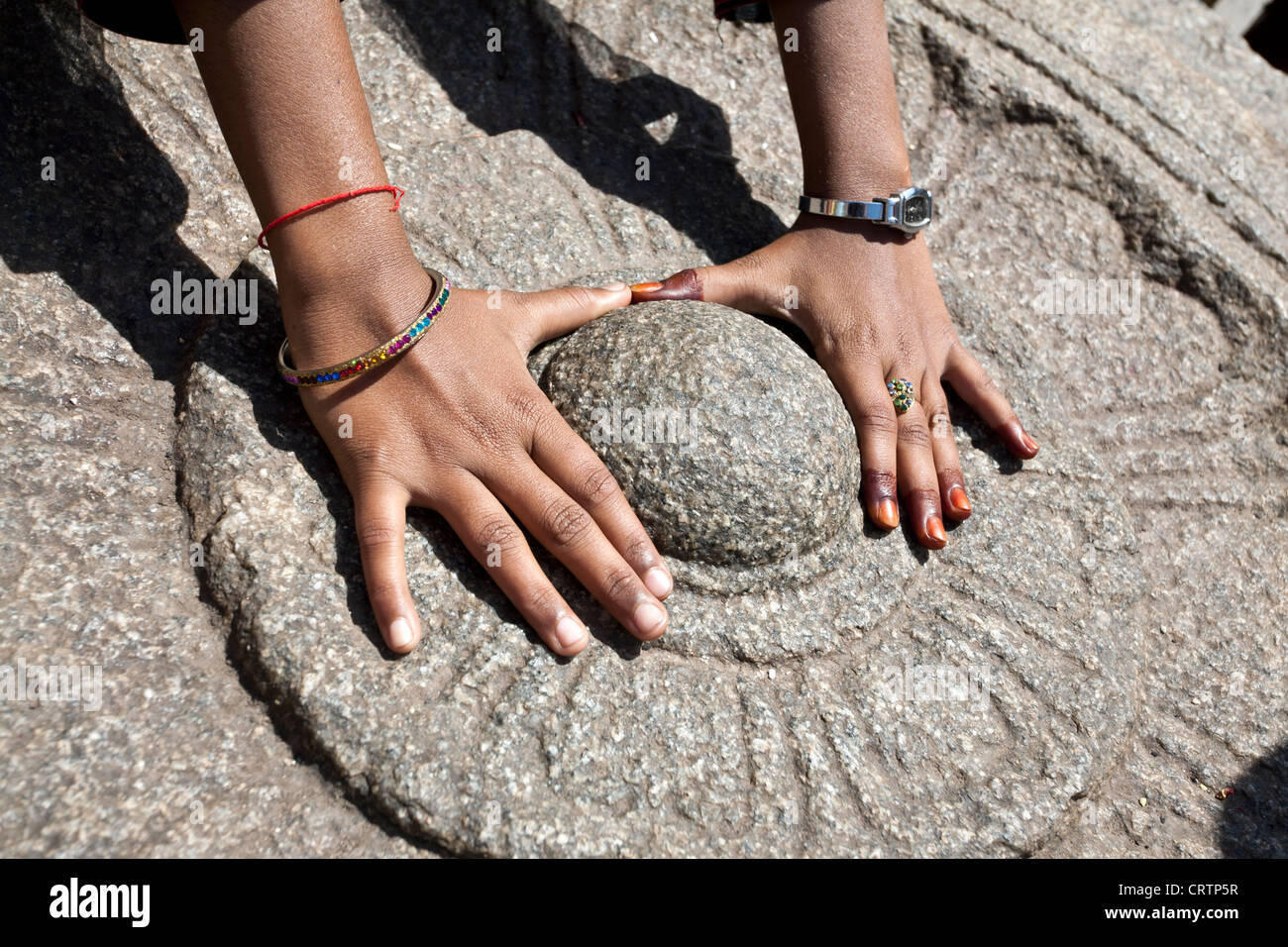 Woman worshiping a sacred stone. Virupaksha temple. Hampi. India Stock Photo