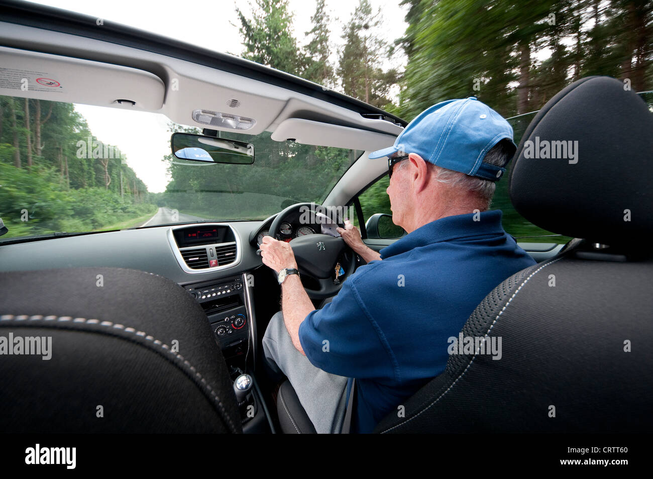 senior man driving open top sports car Stock Photo