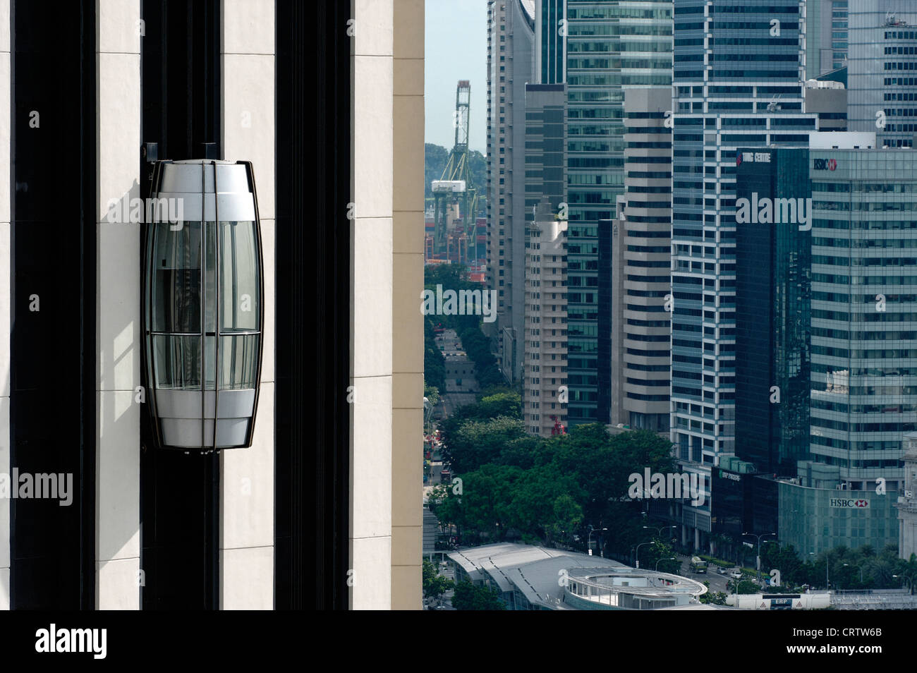 The external lift (elevator) on the Pan Pacific hotel in Singapore. The central financial district is in the background. Stock Photo