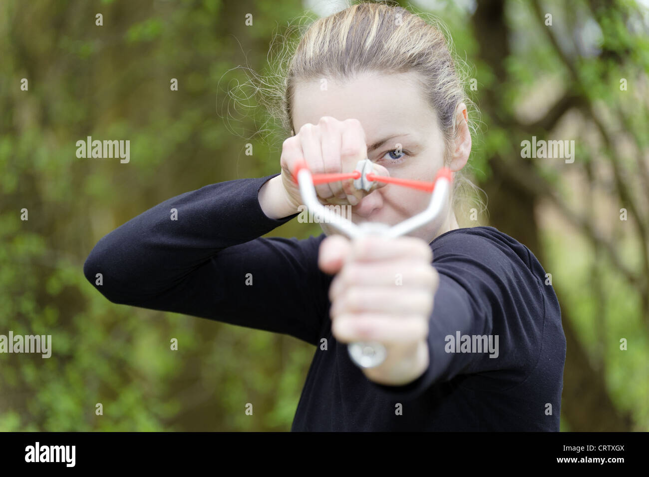 young woman with a catapult aimed Stock Photo