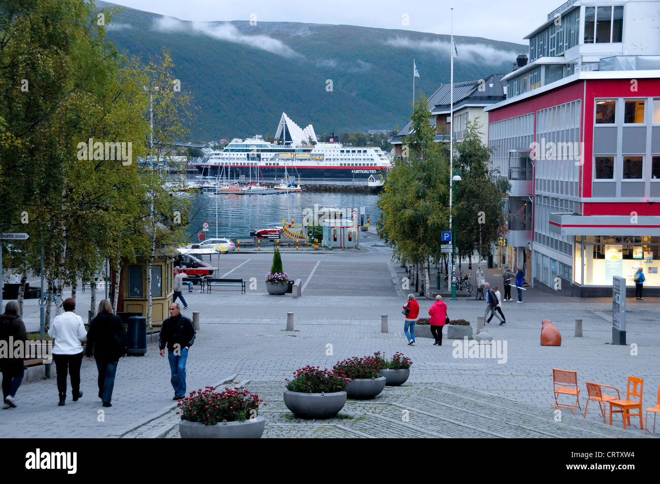 Center of the city of Tromso, the famous Coastal Express, Hurtigruten, passing in background. Stock Photo