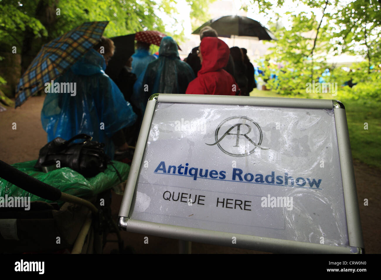 Antiques Roadshow sign with people queuing n the heavy rain at Cawdor Castle in Scotland 2012 Stock Photo