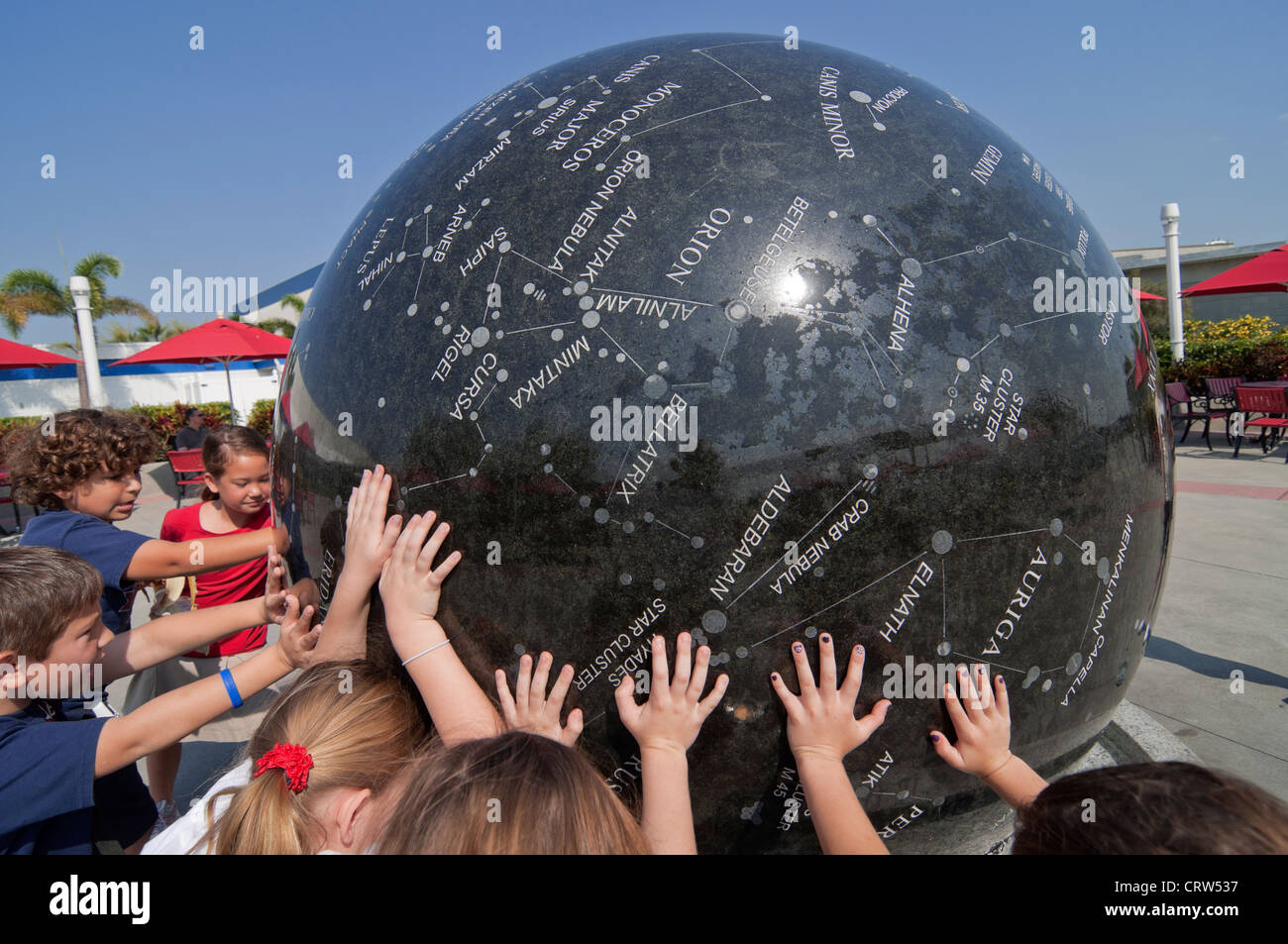 Kennedy Space Center Visitor Complex on Merritt Island Florida school kids turn 9 ton granite constellation sphere. Stock Photo