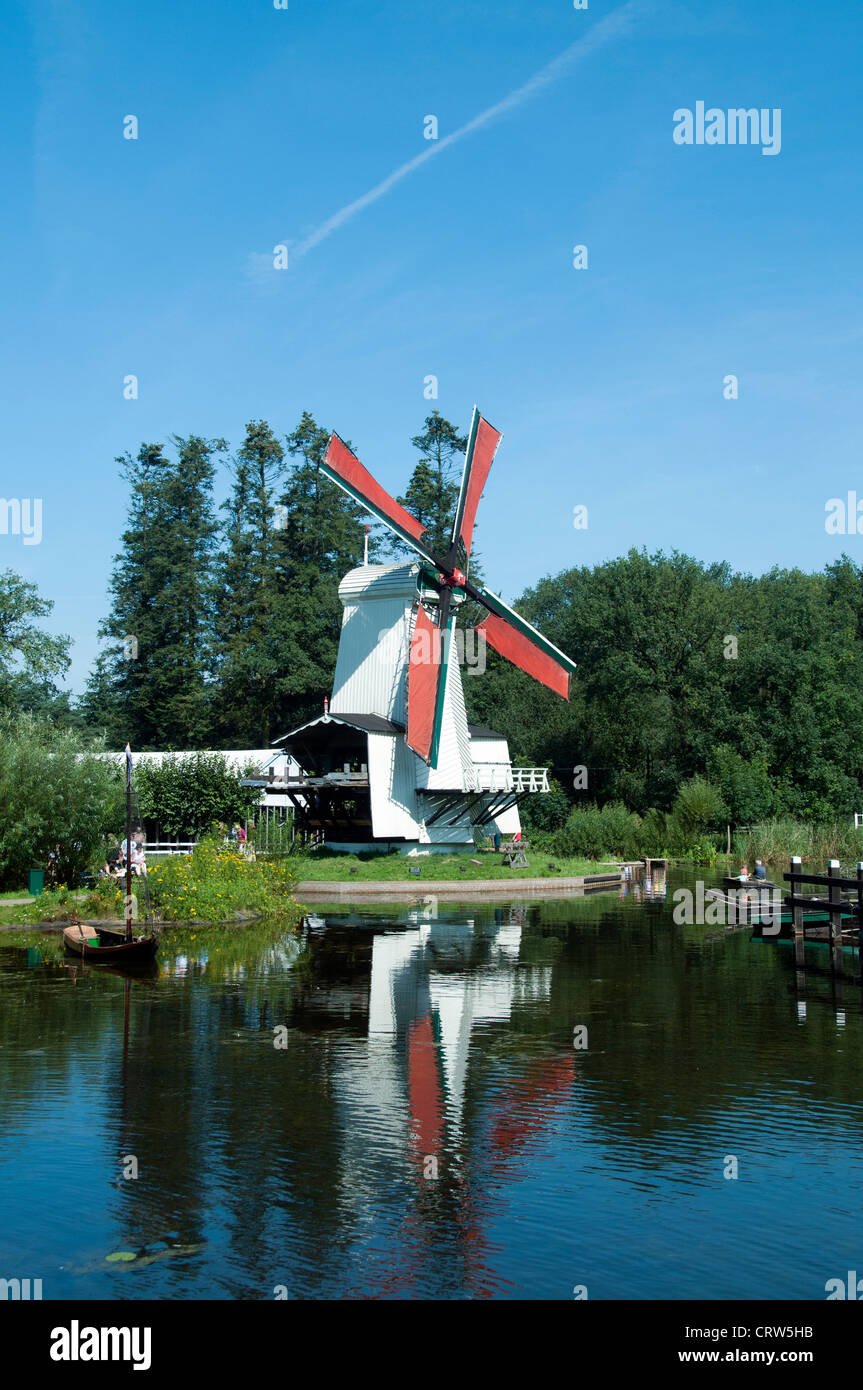 windmill in Holland with blue sky and reflection in water Stock Photo