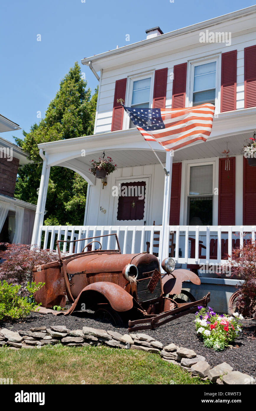 Rusting tin lizzie decorates a front yard in Adamstown, Pennsylvania, Stock Photo