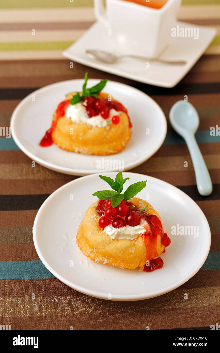 Little sponge cakes with cream and red currants. Recipe available. Stock Photo