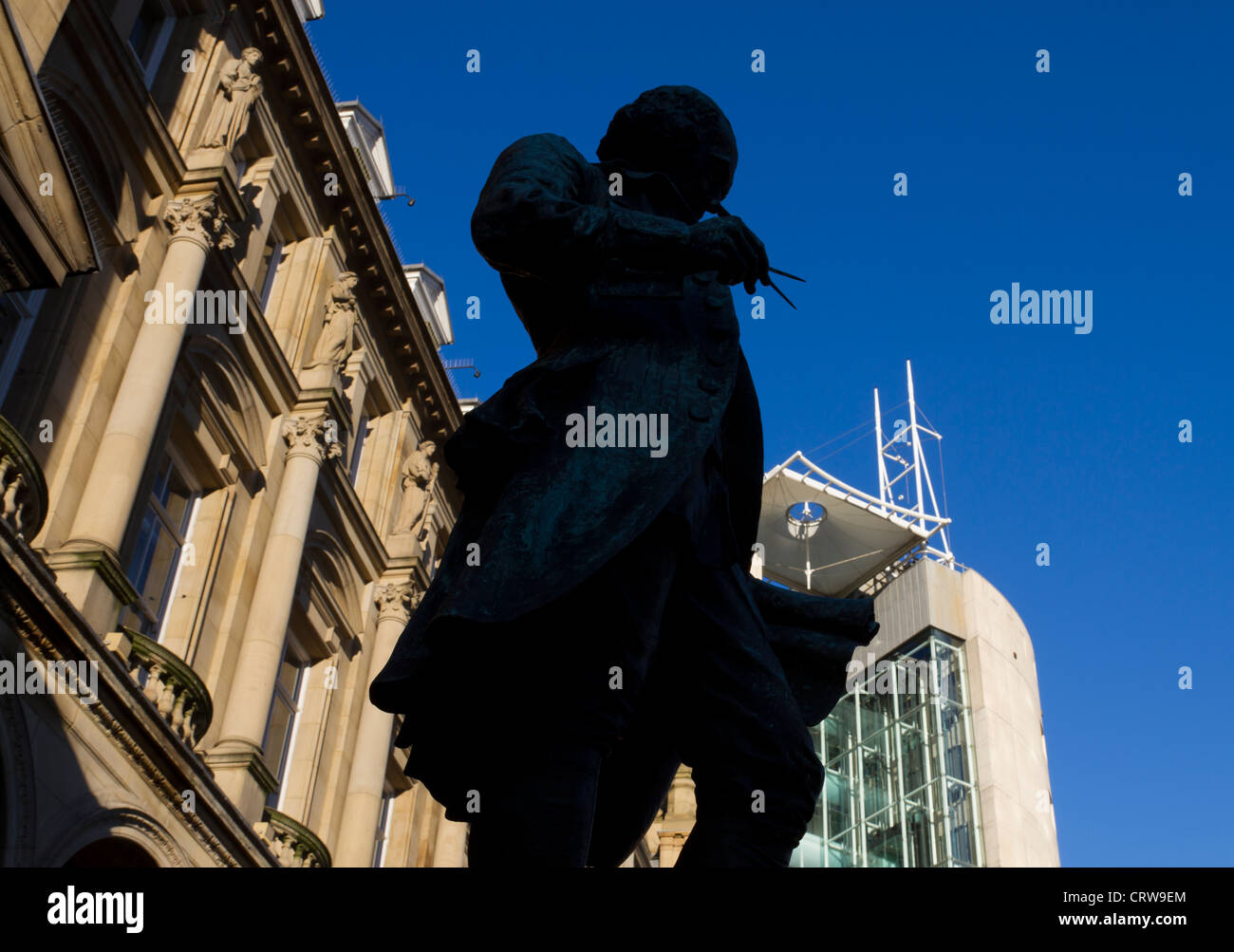 Statues of James Watt, silhouetted in City Square Leeds. Stock Photo