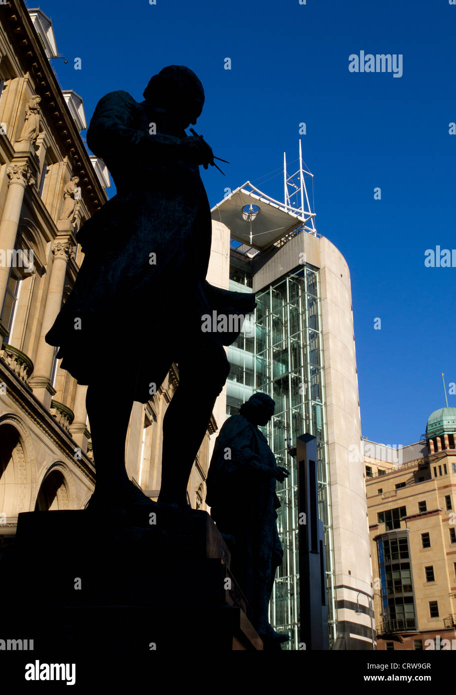 Statues of James Watt and John Harrison, silhouetted in City Square Leeds. Stock Photo