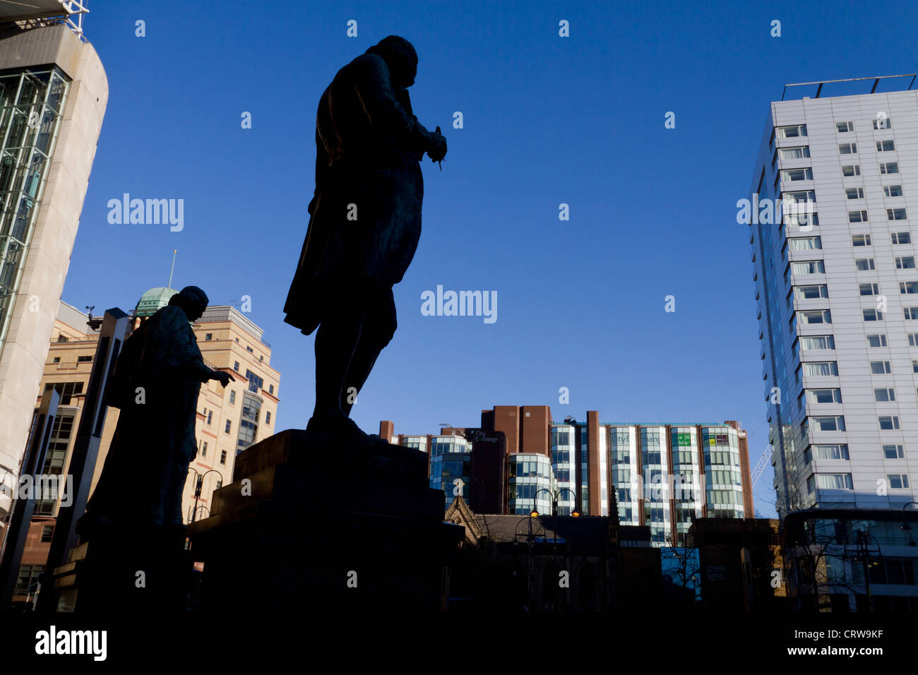 Statues of James Watt and John Harrison, silhouetted in City Square Leeds. Stock Photo