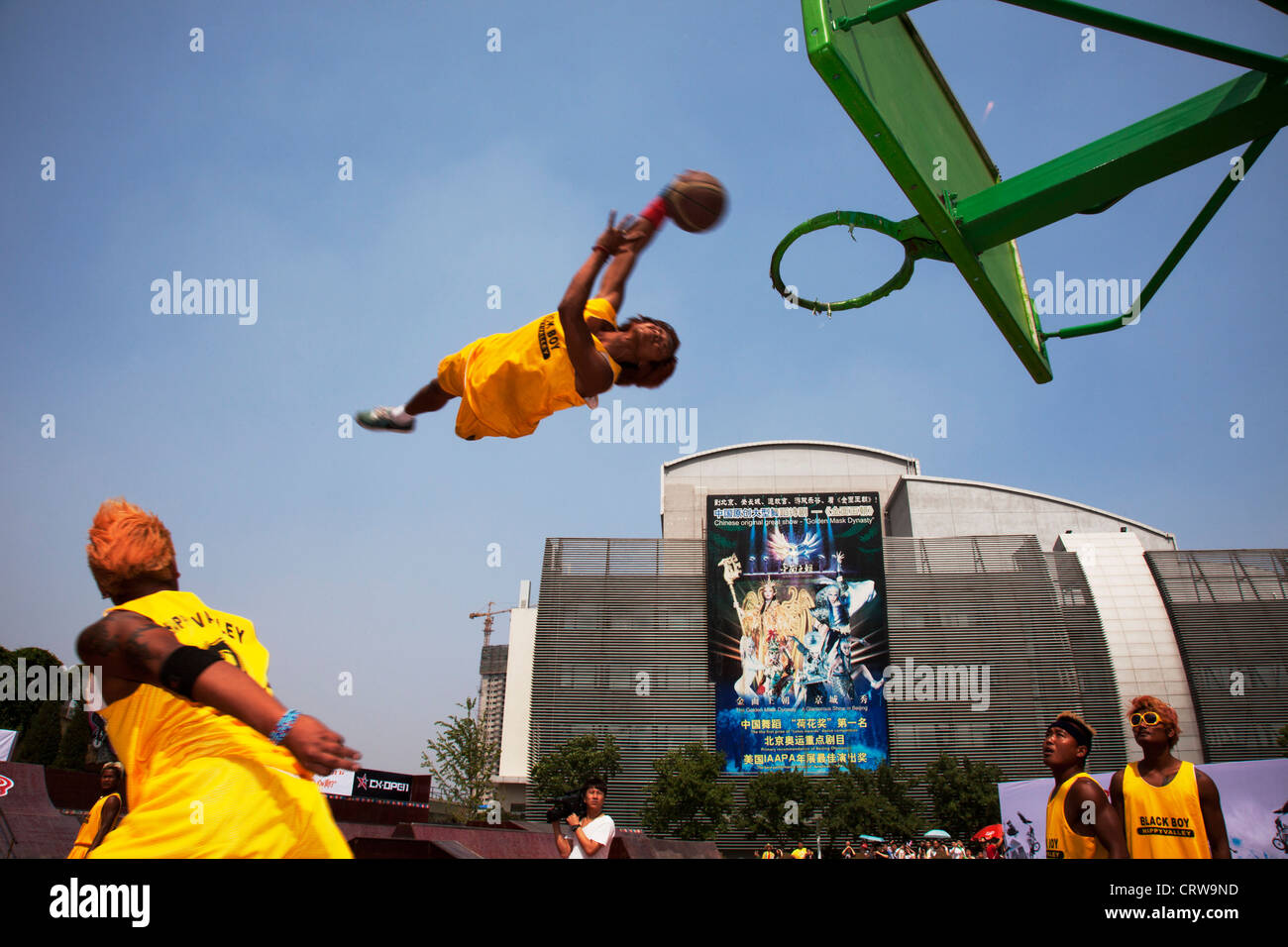 Basketball tricks team perform their slam dunk trick, flying through the air at Happy Valley amusements park, Beijing, China. Stock Photo