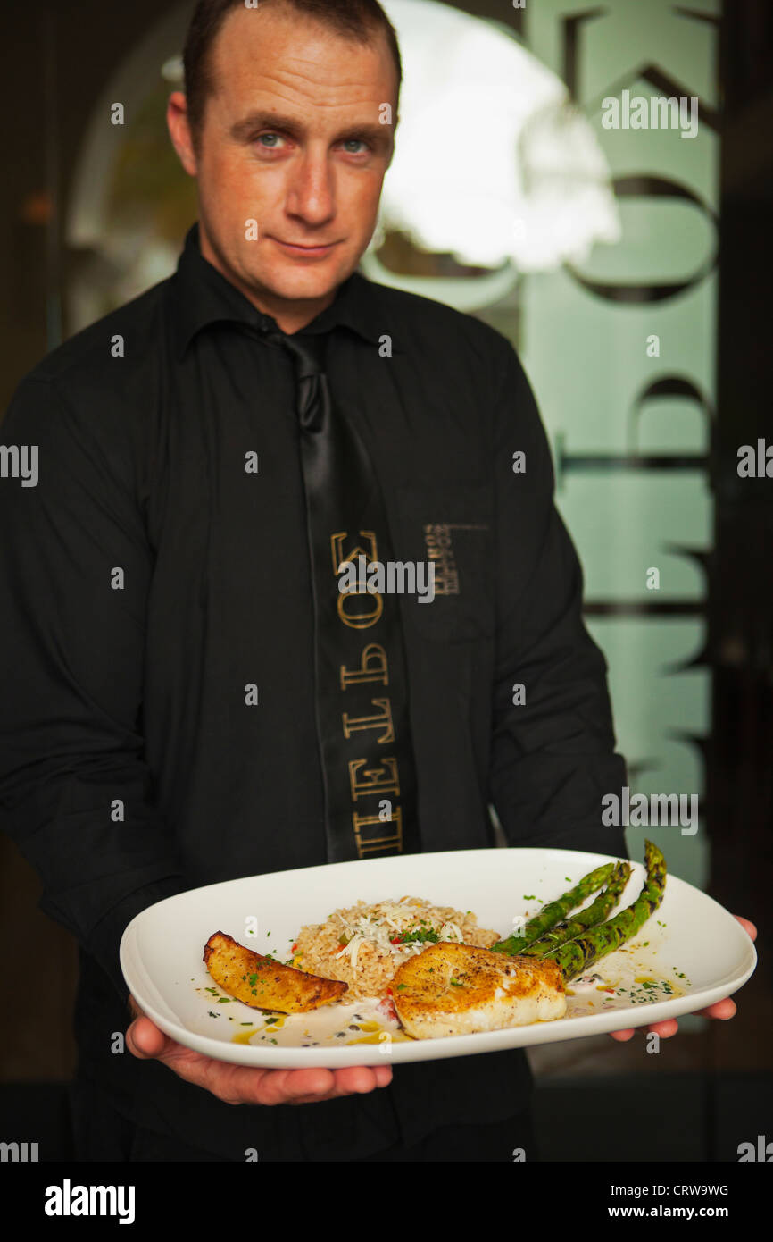 man serving sauteed sea bass with asparagus, Petros Greek Restaurant