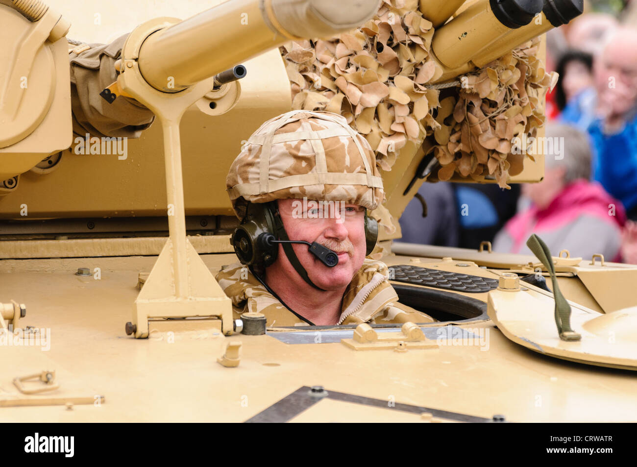 Soldier in desert fatigues drives a Scorpion reconnaisance vehicle Stock Photo