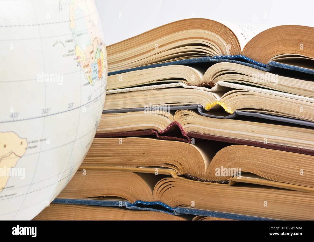 stack of open books and Globe Stock Photo - Alamy