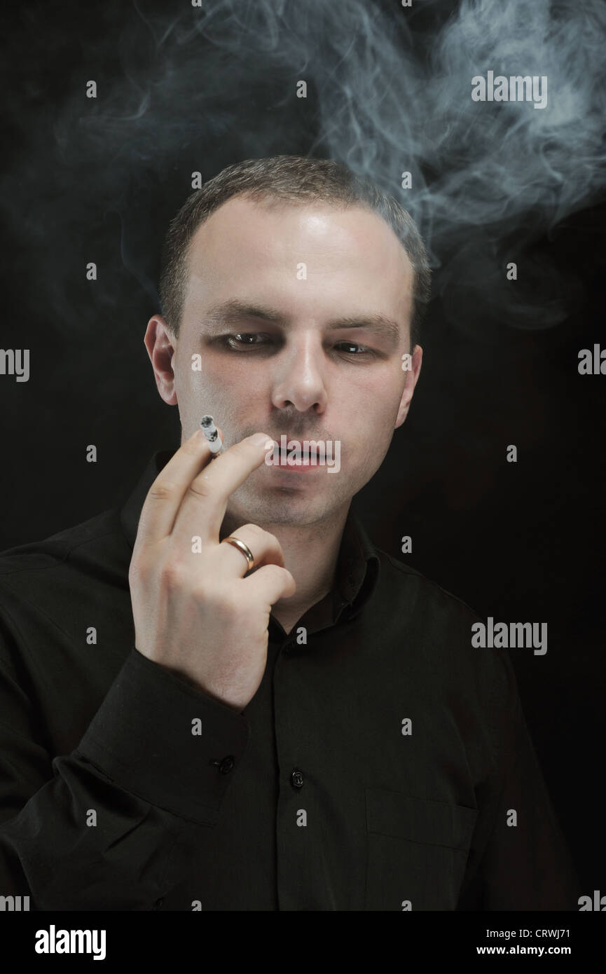 young man smokes a cigarette Stock Photo Alamy