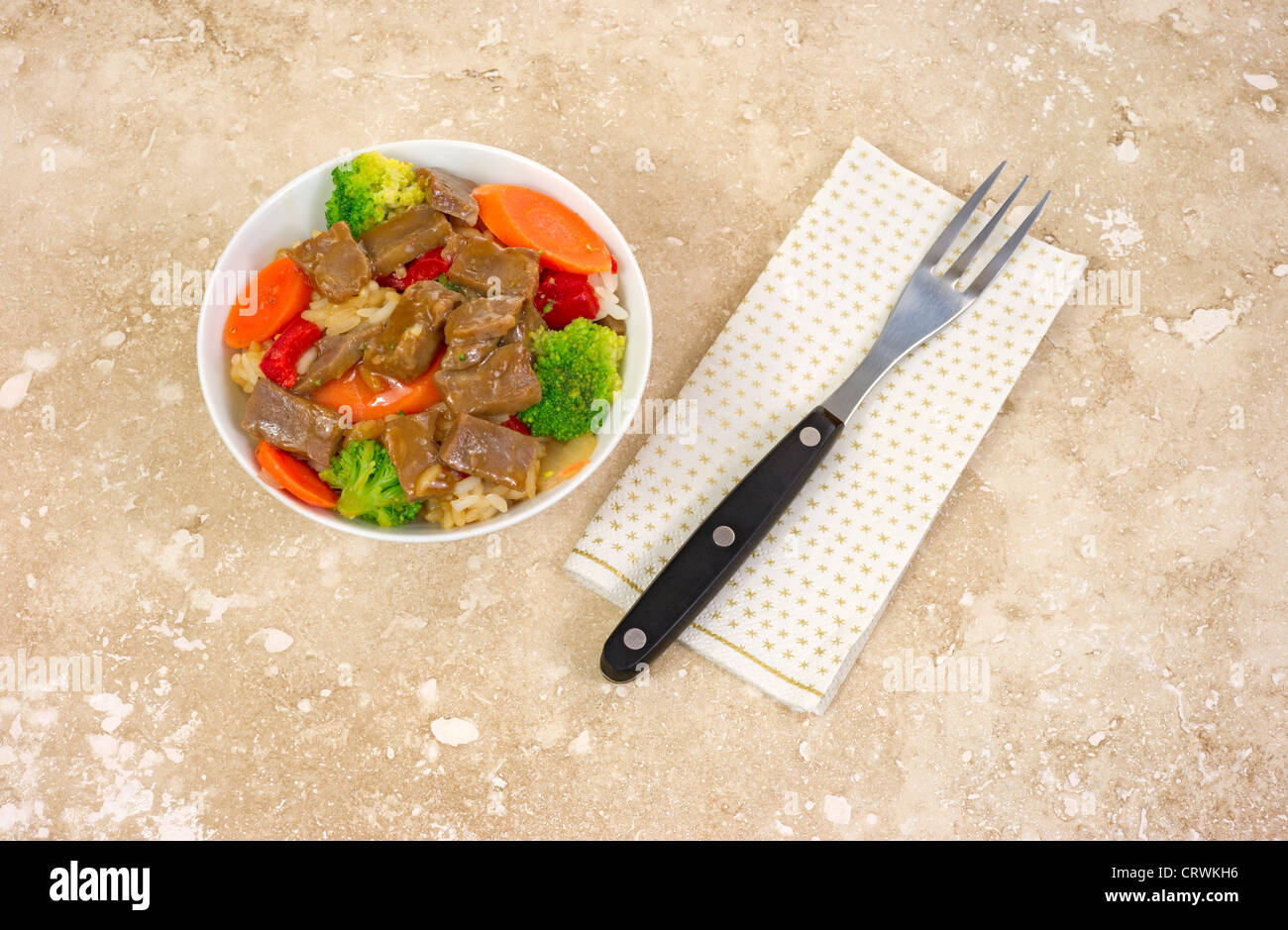 Small serving of beef teriyaki with fork on napkin Stock Photo
