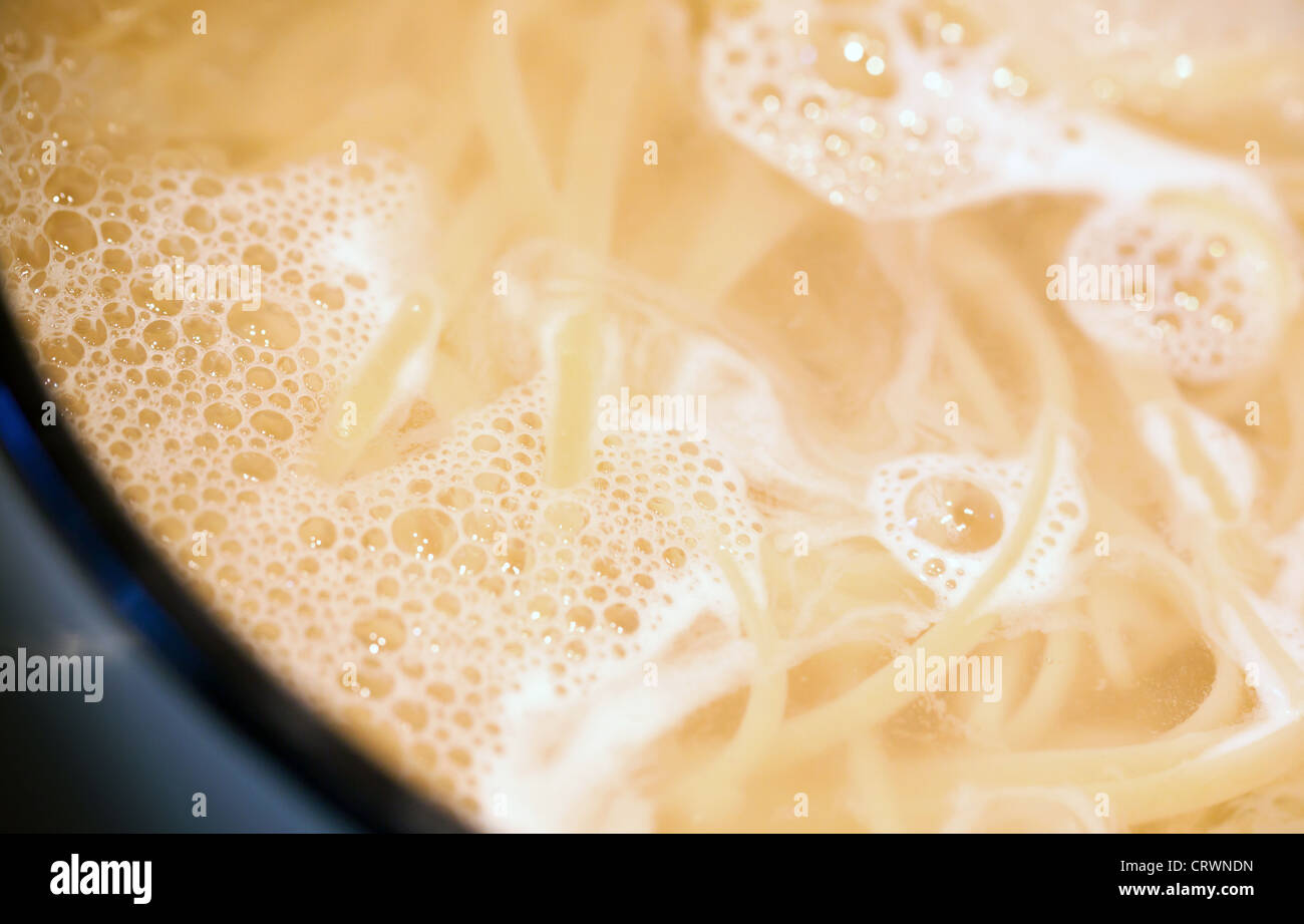 Boiling water with noodles in the pan Stock Photo