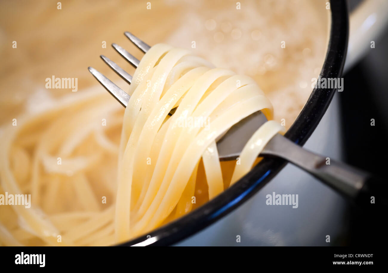 Noodles in the pan with fork Stock Photo Alamy