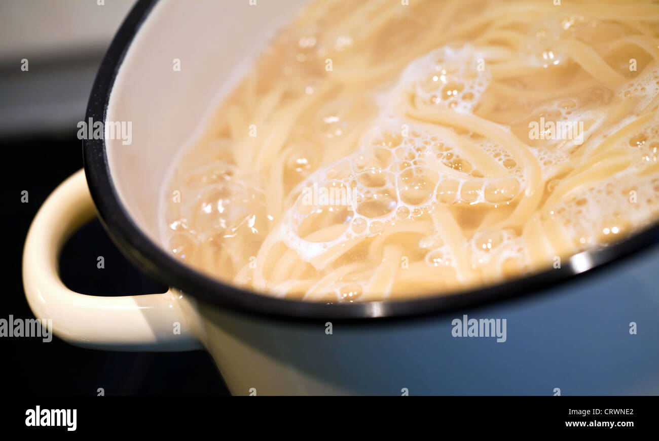 Boiling water with noodles in the pan Stock Photo