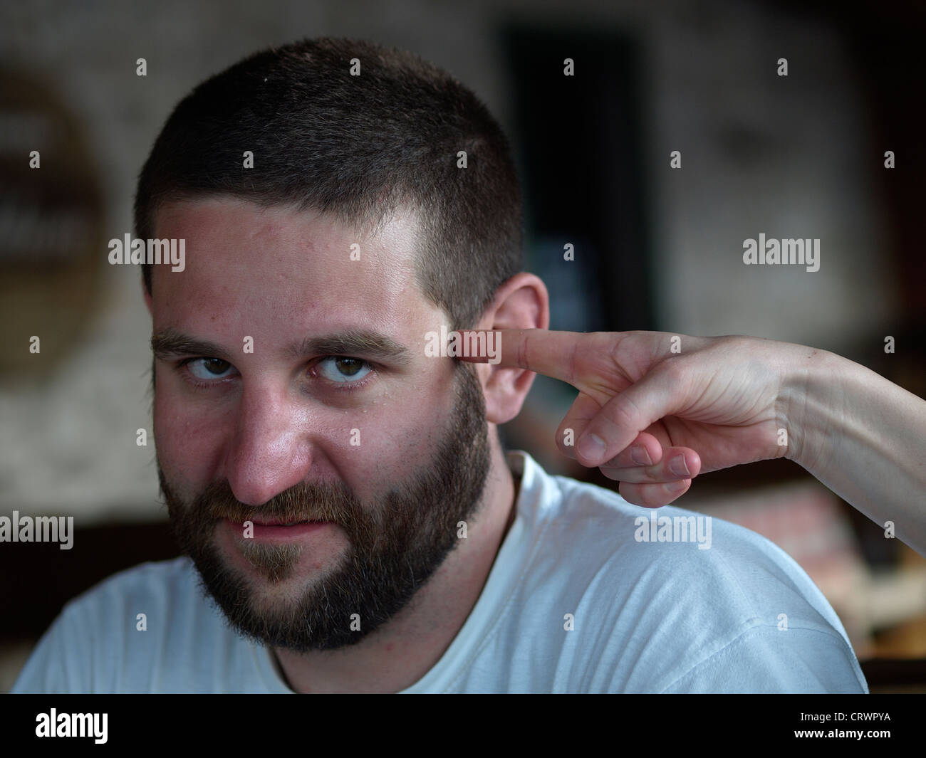 Lady finger point at young man's head Stock Photo