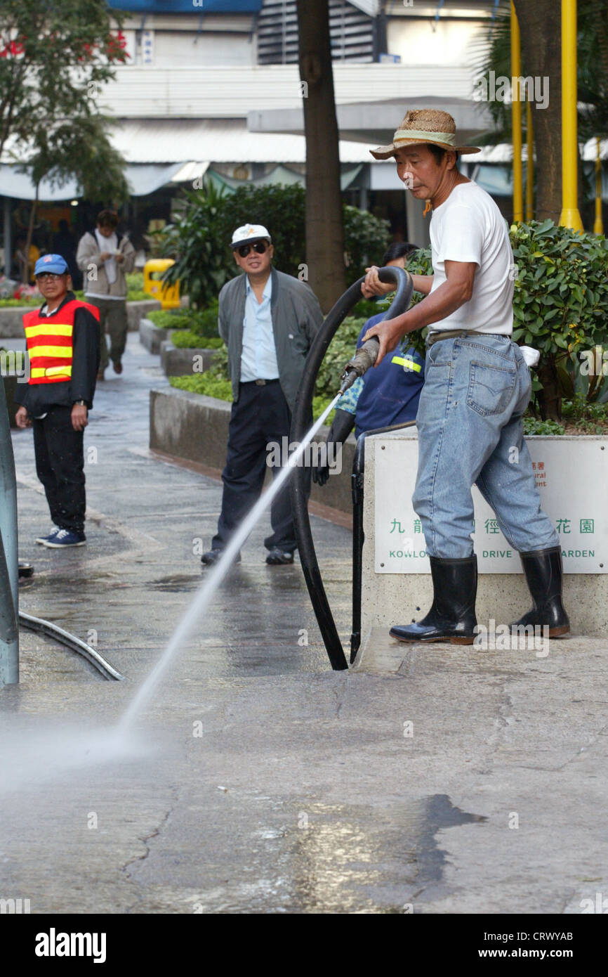A man in cleaning the streets in Kowloon Stock Photo