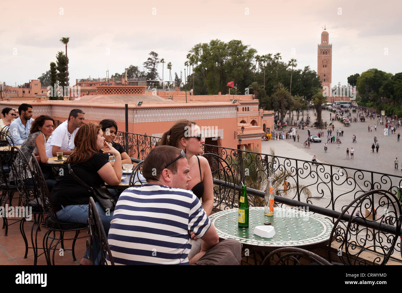 Tourists in Cafe Glacier, looking over Djemaa el Fna Square towards the Koutoubia Mosque, Marrakech Morocco Stock Photo