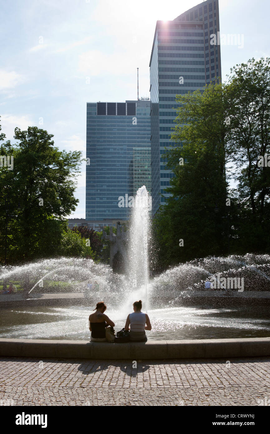 Two girls sit by a fountain in the Warsaw city centre, Poland Stock Photo