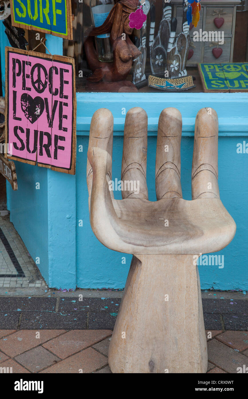 Wood carving of a hand in the shape of a chair, at an Indian shop in Perranporth Stock Photo