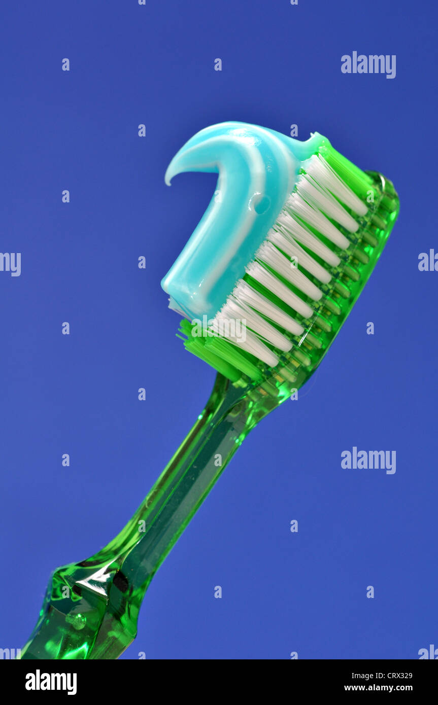 A green tooth brush with blue and white tooth paste on it Stock Photo ...