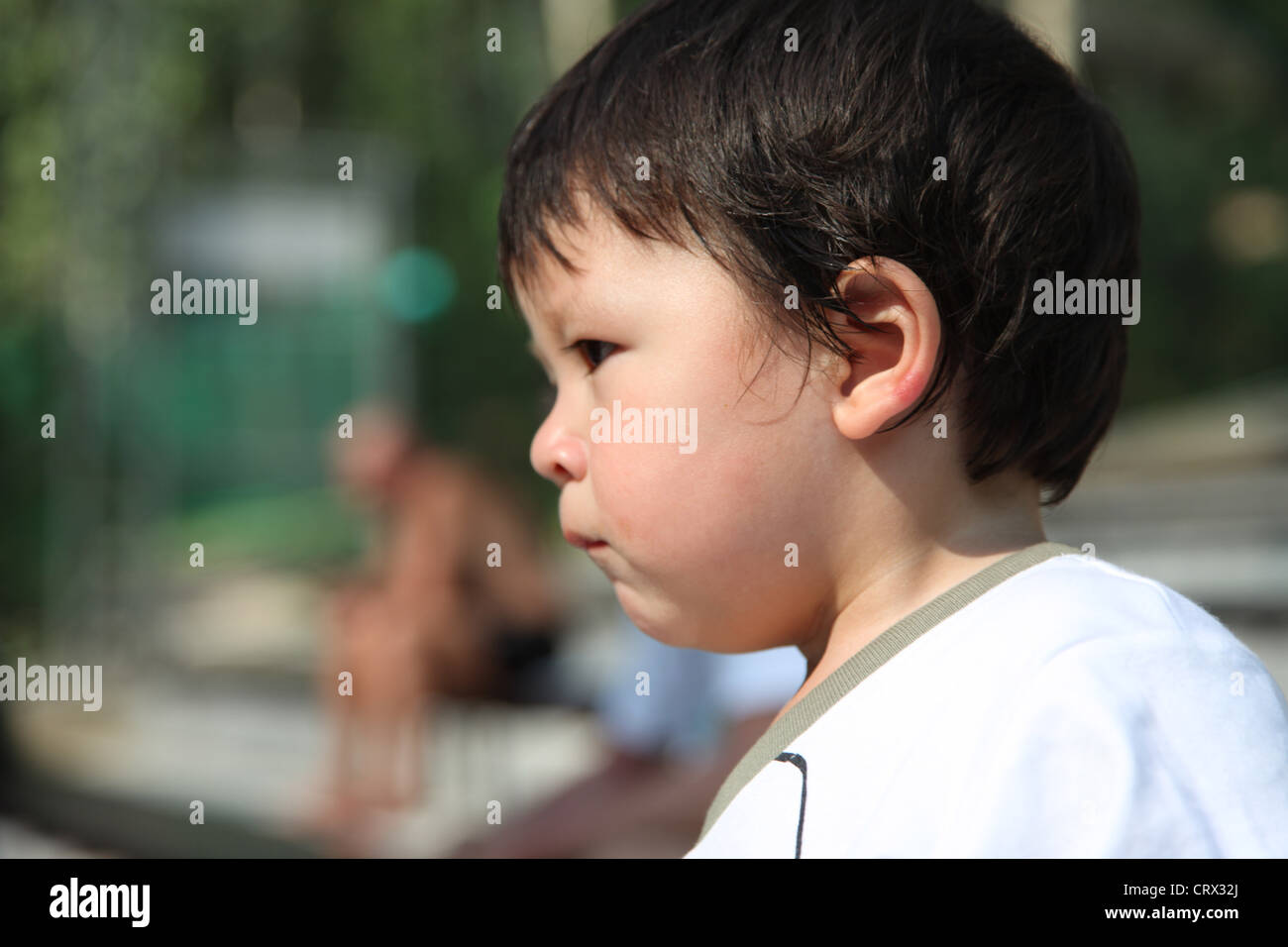 It's Chinese Eurasian baby Boy who is the center of this photo. he thinks  dreams literally drinking life. He sits on wood chair Stock Photo - Alamy