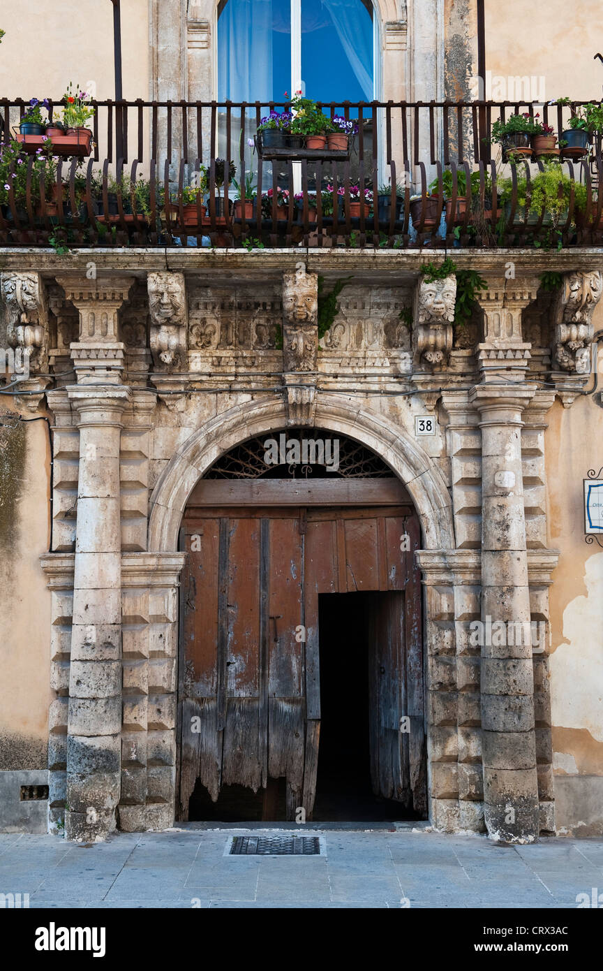 Grotesque heads ornament the facade of an old house in Palazzolo Acreide, southern Scily, Italy Stock Photo