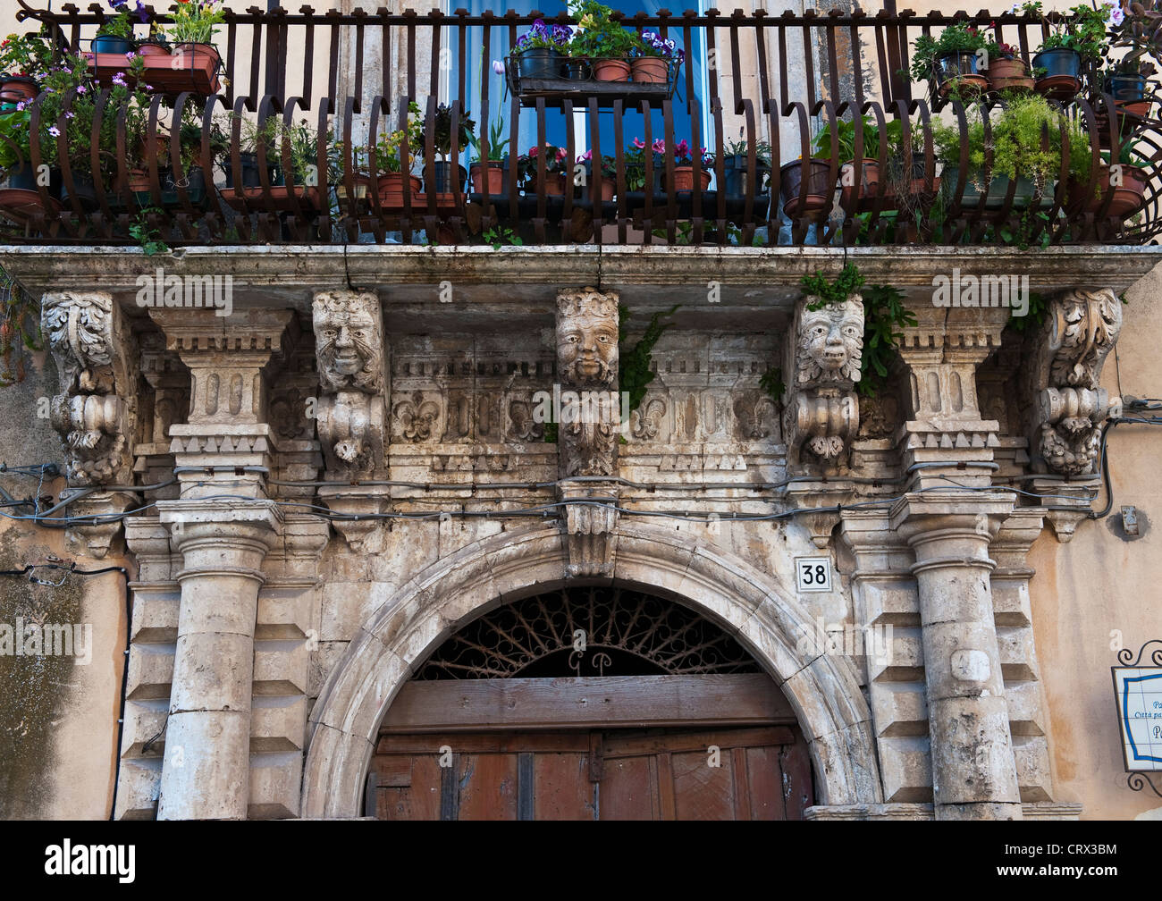 Grotesque heads ornament the facade of an old house in Palazzolo Acreide, southern Scily, Italy Stock Photo