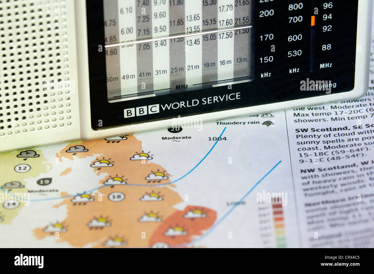 A BBC World Service radio resting on a newspaper weather map or chart. Stock Photo