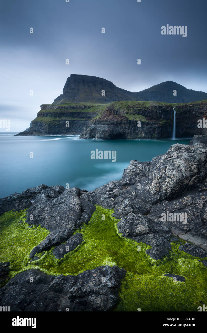 Dramatic coastline and waterfall at Gasadalur on the Island of Vagar, Faroe Islands. Spring (June) 2012. Stock Photo