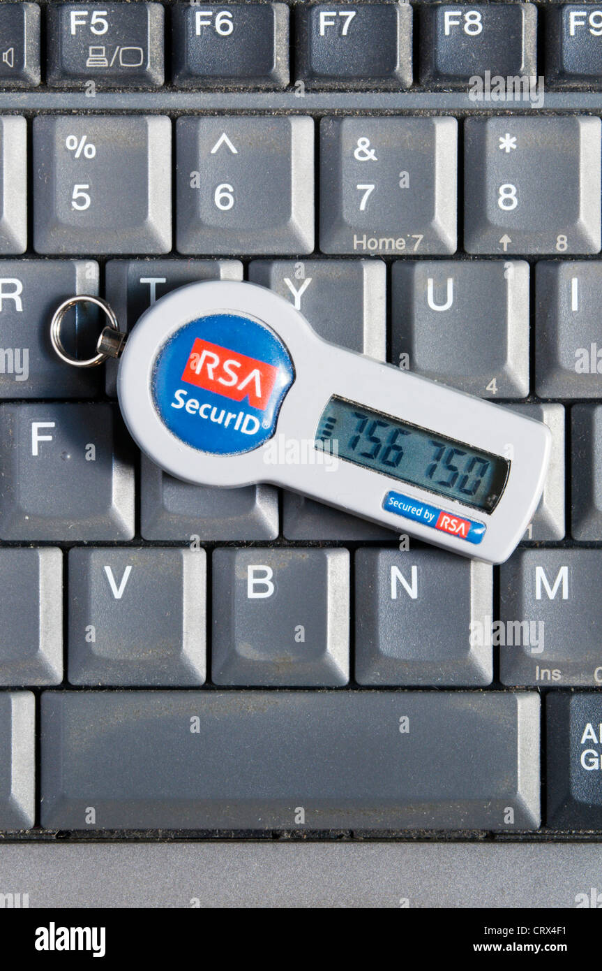 An RSA SecurID security token resting on the keyboard of a laptop computer. Stock Photo