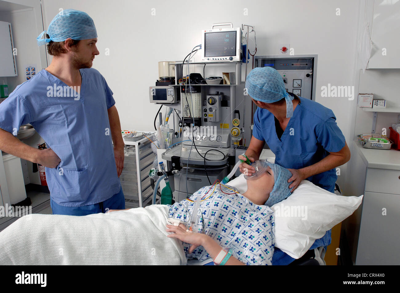 An anaesthetist administering medical gases to put a patient to sleep at the start of an operation. Stock Photo