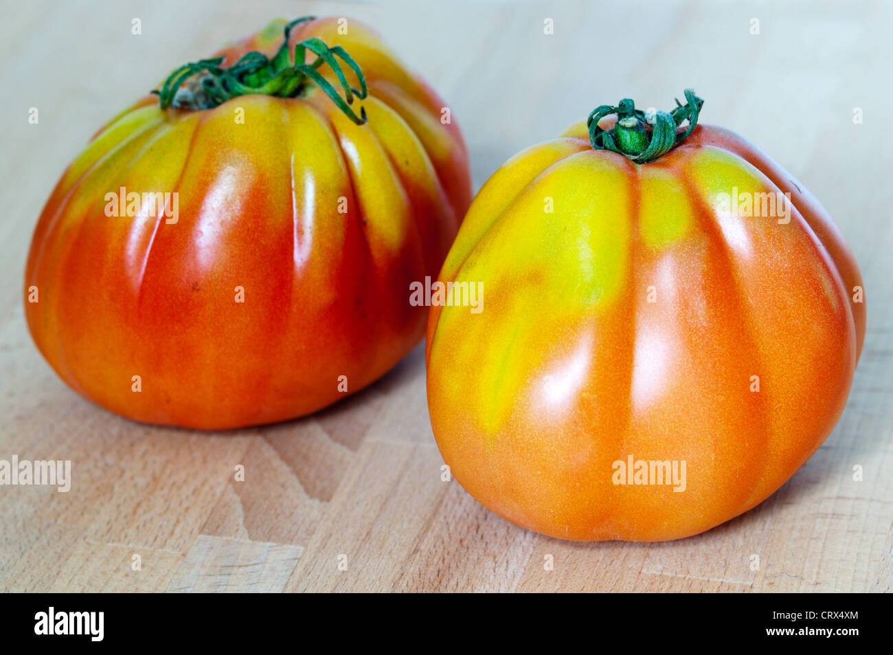 Two Italian Cuore di Bue tomatoes. Stock Photo