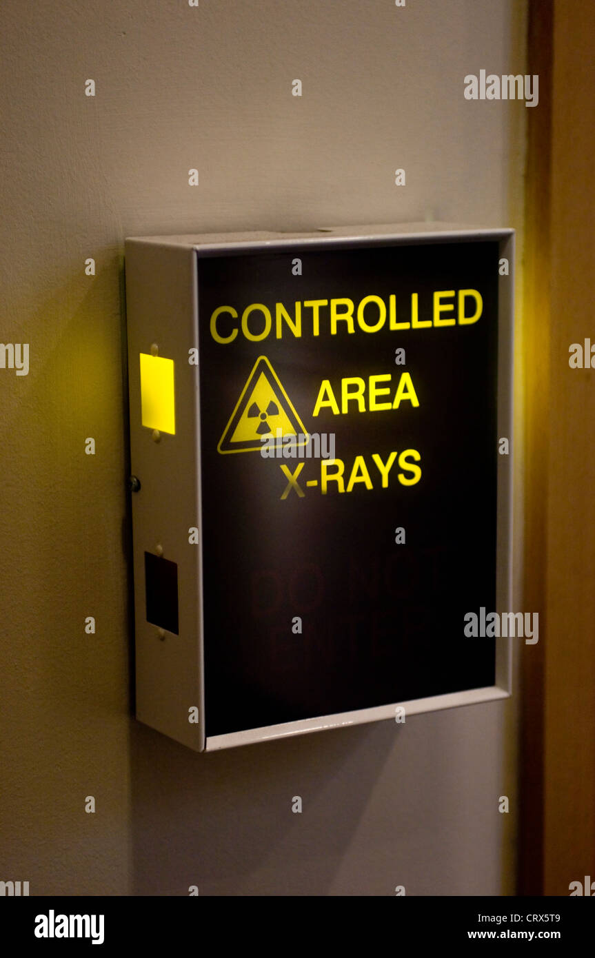 An illuminated hospital sign outside a controlled area for x-rays Stock Photo
