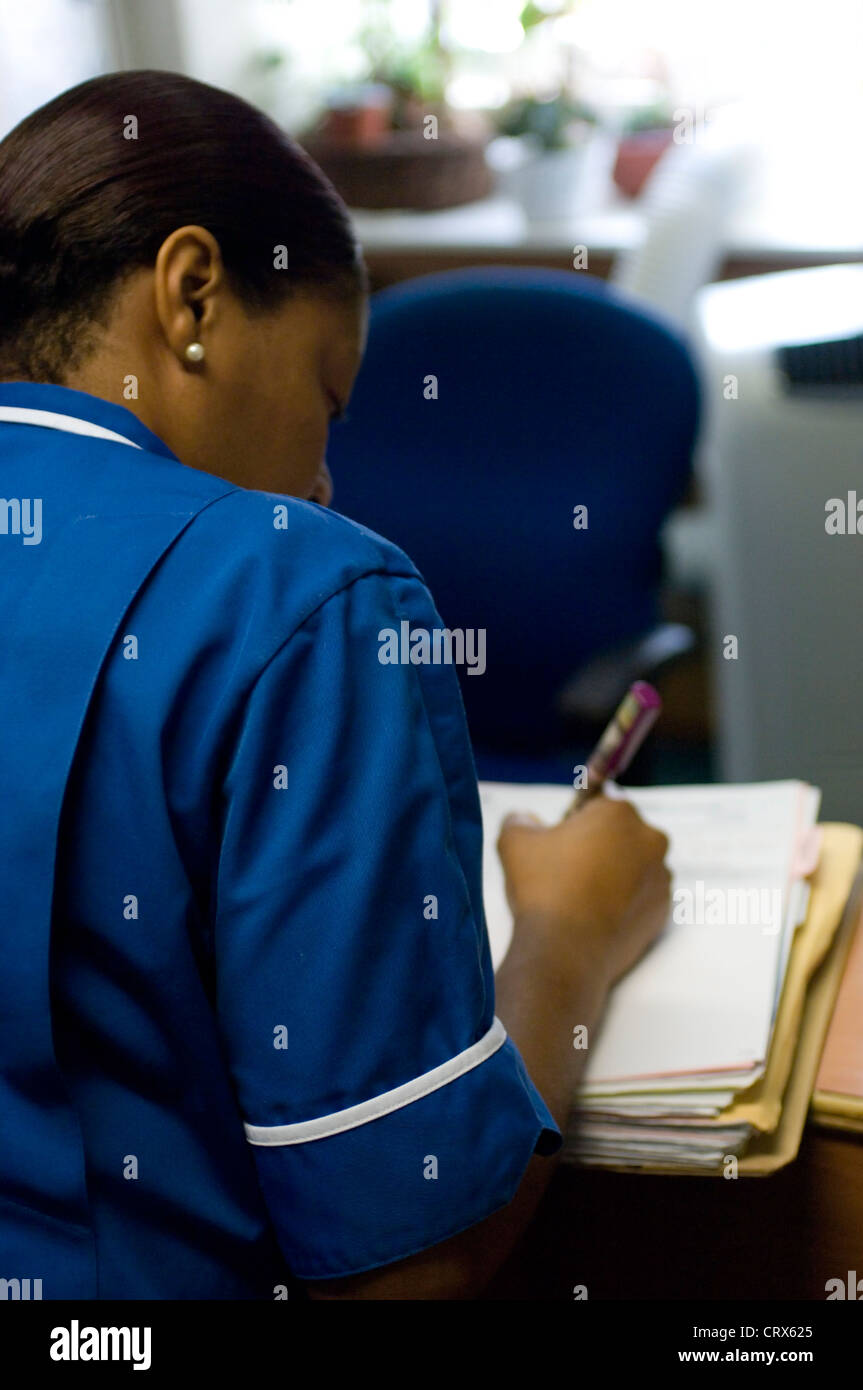 Nurse in dark blue uniform writing up patient hires stock photography