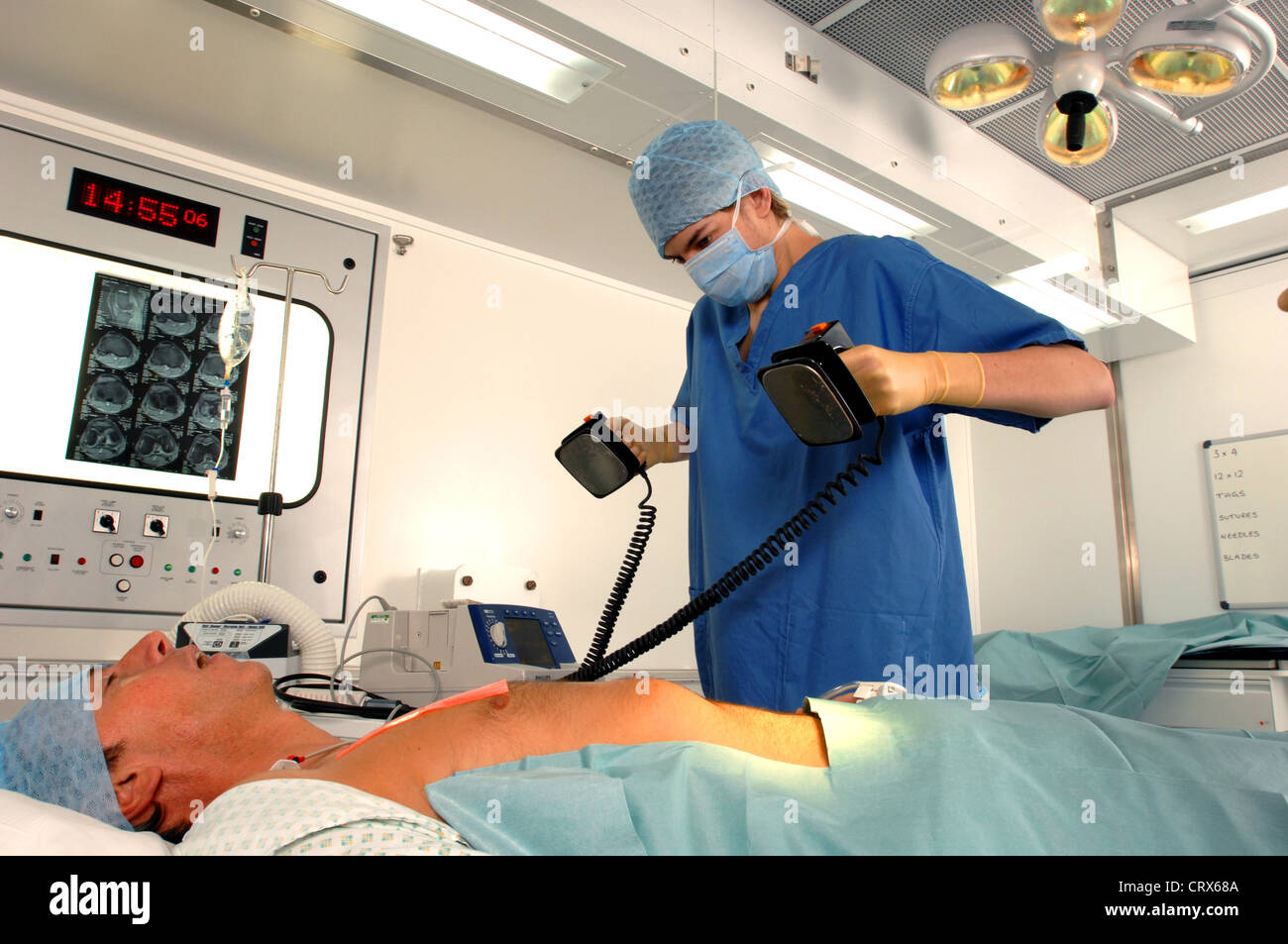 Doctor using a defibrillator to resuscitate a male heart attack victim. Stock Photo