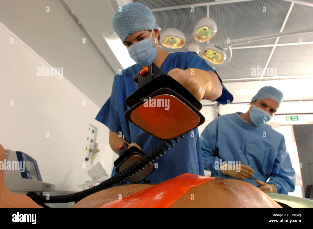 Doctors using a defibrillator to resuscitate a male heart attack victim. Stock Photo