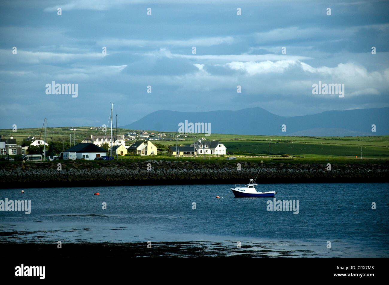 A dusk view across the harbour in Dingle peninsula, Ireland, to the Kerry mountains beyond Stock Photo