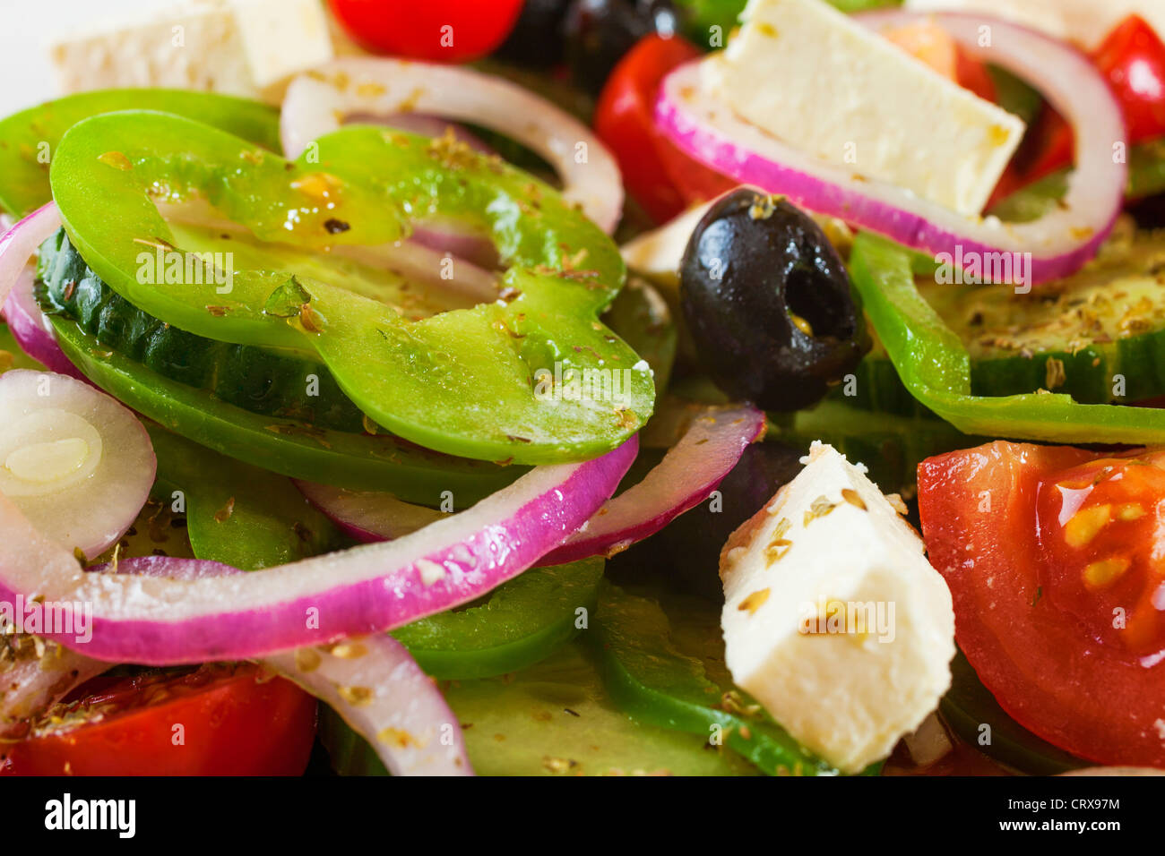Greek salad, with tomatoes, red onions, green capsicums, cucumber, black olives, feta cheese and herbs. Stock Photo