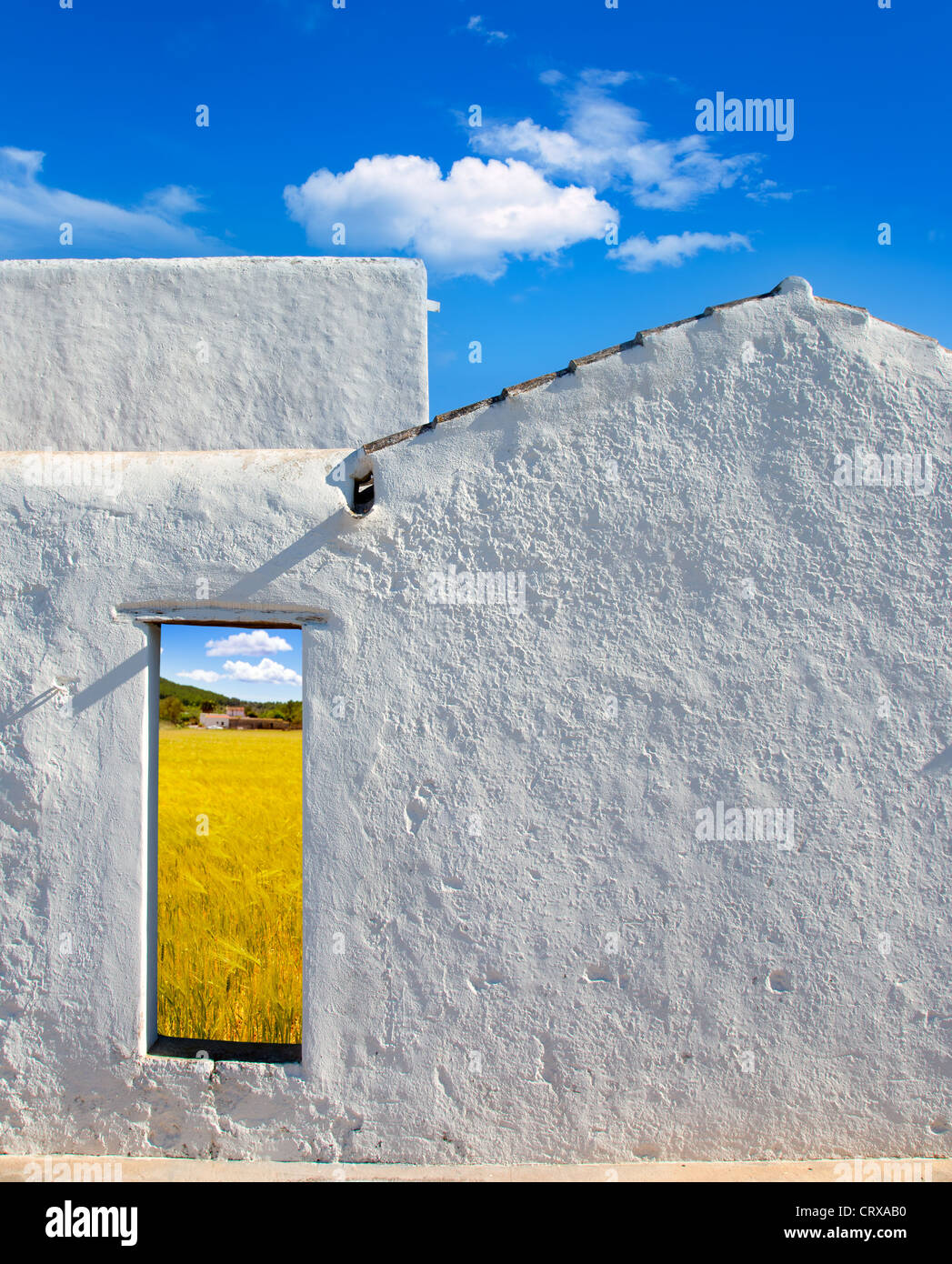 Balearic islands golden wheat field view through whitewashed house open door Stock Photo