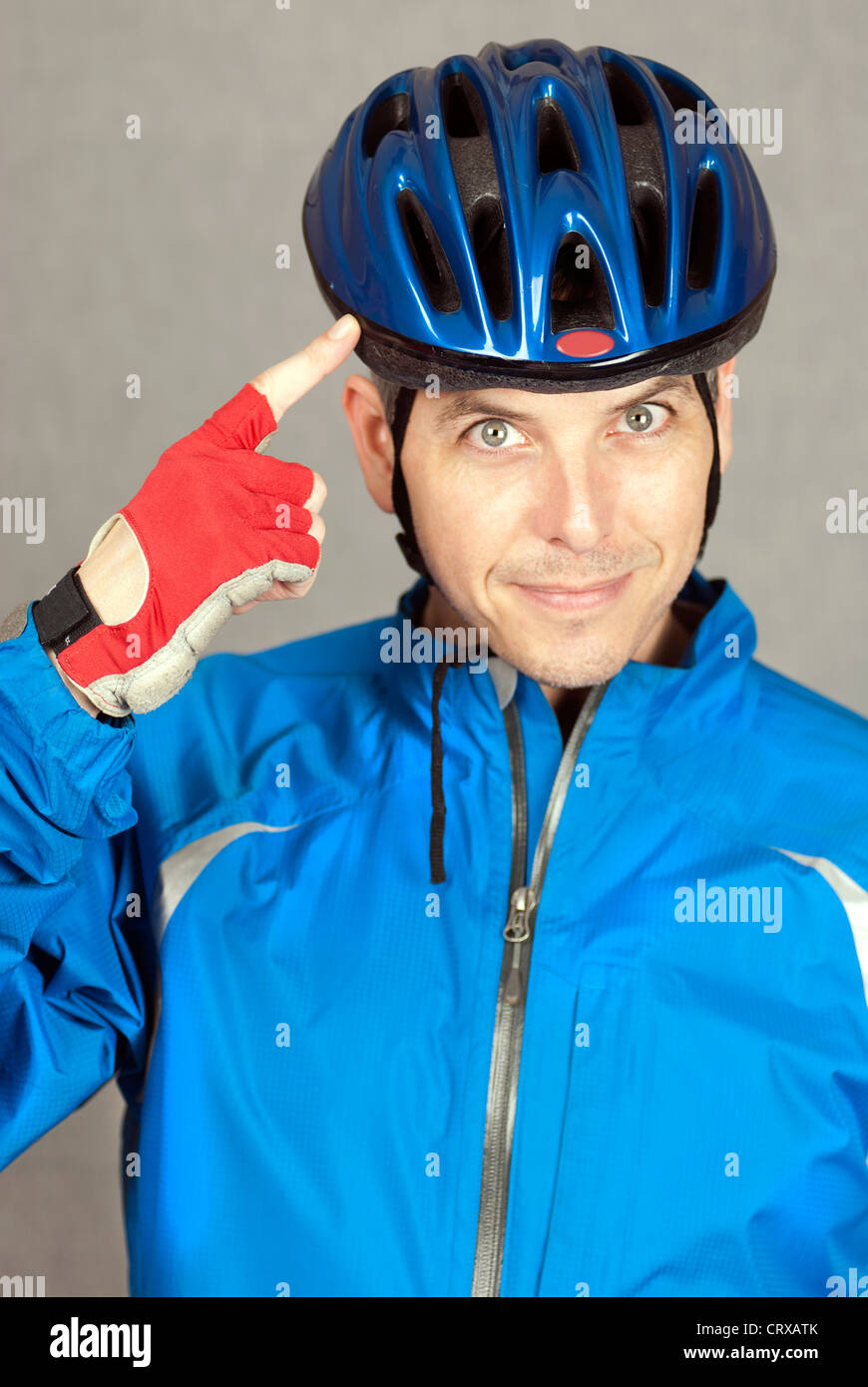 A close-up shot of a cyclist pointing at his helmet. Stock Photo